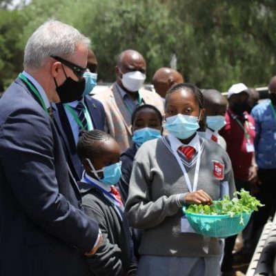 A student from Tender Care Junior Academy guiding the Australian High Commissioner on how to plant vegetables during the launch of FEGNe Agritech Program